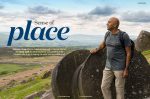 Image of 1st double page spread of Viv Crow's article "A sense of Place" showing Amar Latif standing against three Peak District Millstones on Stanage Edge, and high above a road junction.